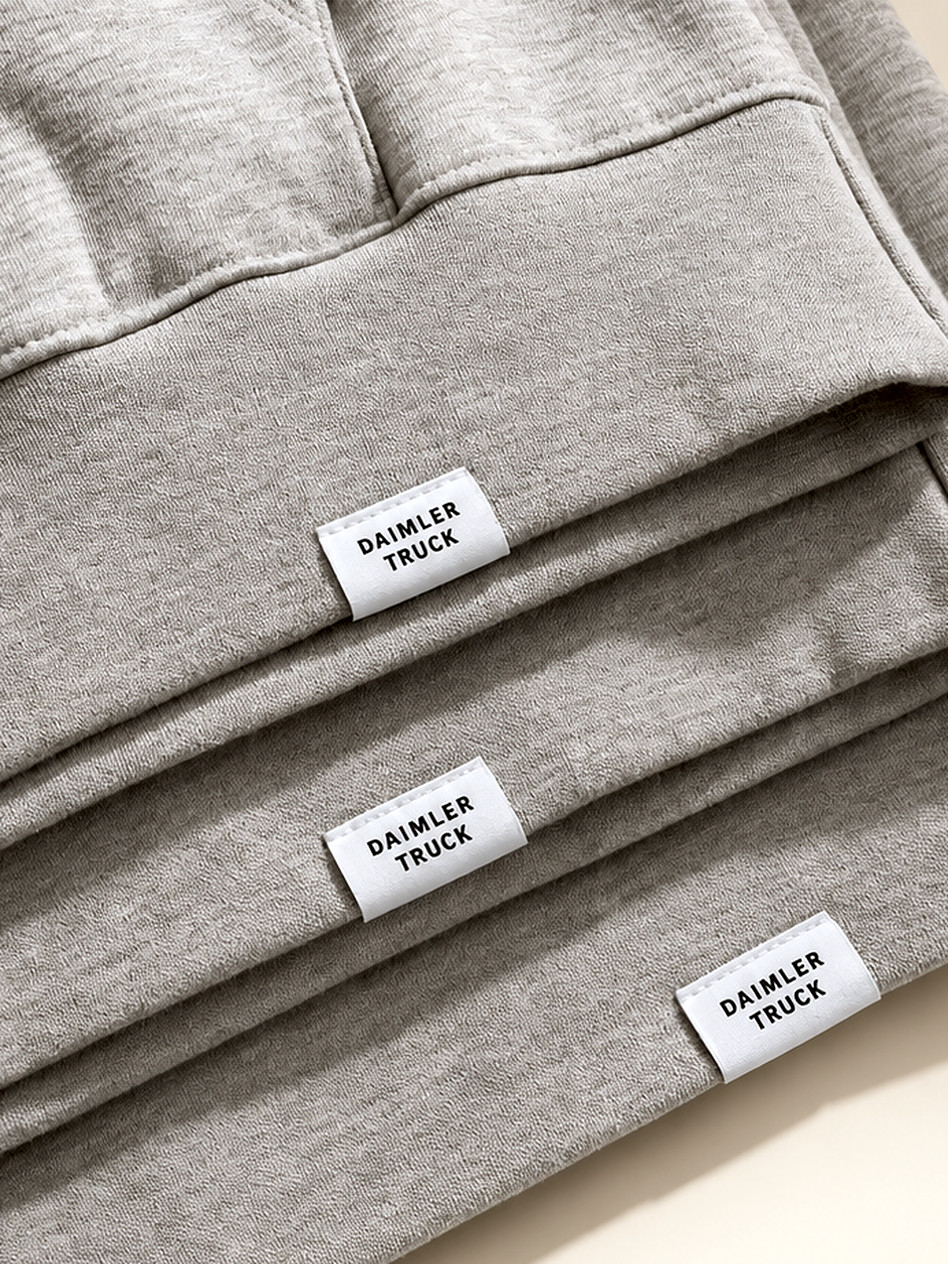 Folded heather grey hoodies with woven Daimler Truck labels